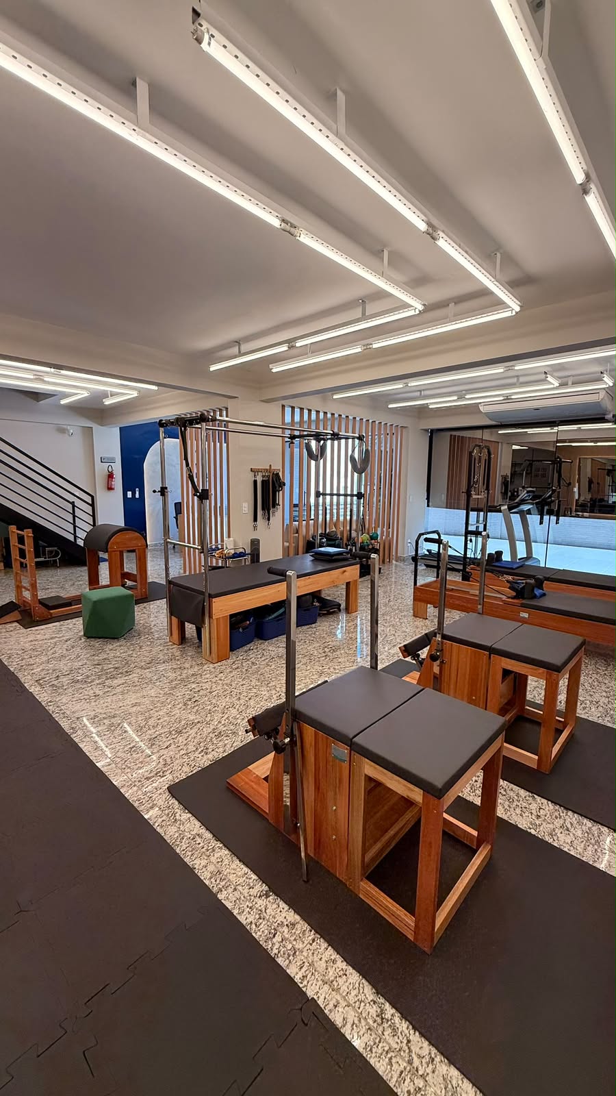 Sala de Pilates com equipamentos, acessórios e bolas de exercício.